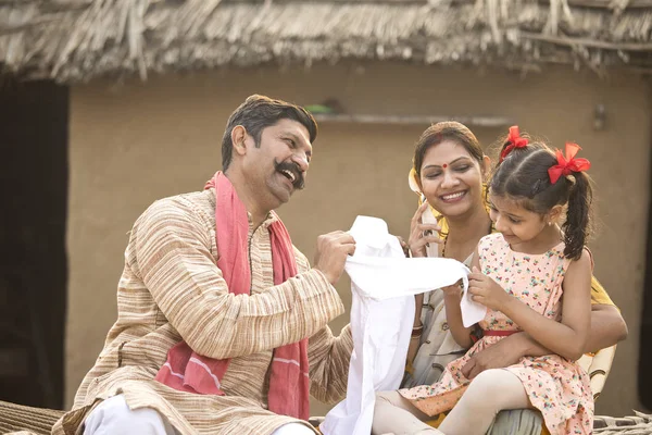 Farmer gifting new dress to little daughter — Stock Photo, Image