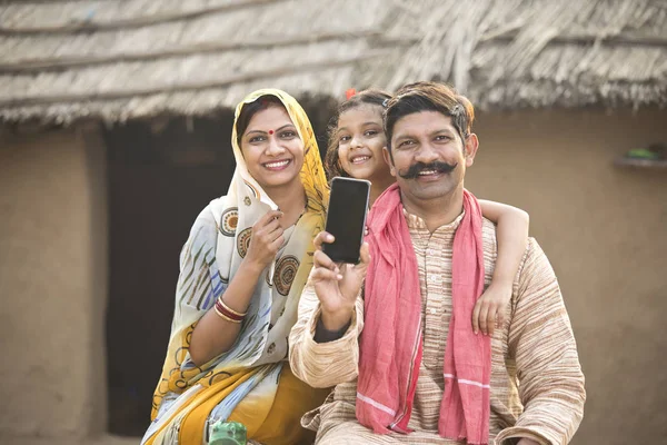 Yeni cep telefonu köyde gösterilen kırsal Hint aile portresi