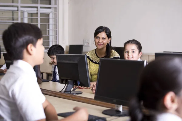 Indischer Lehrer hilft Schülern im Computerkurs — Stockfoto