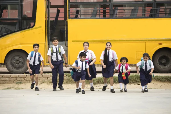 Schoolboys och skolflickor Walking av skolbussen — Stockfoto