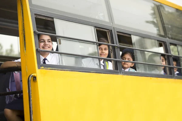 Boldog iskolás gyermekek látszó-ból ablak iskolabusz — Stock Fotó
