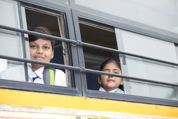 Happy skolbarn tittar från fönster av Skolbuss — Stockfoto