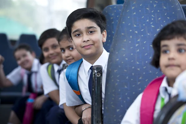 Iskolás gyermekek utazik az iskolabusz nézi kamera — Stock Fotó