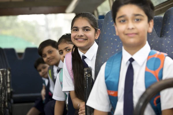 Iskolás gyermekek utazik az iskolabusz nézi kamera — Stock Fotó