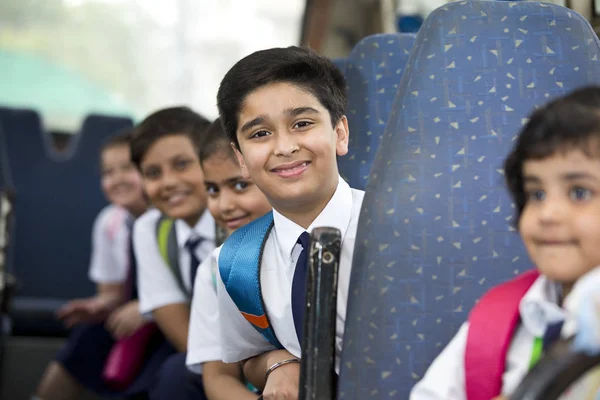 Crianças da escola viajando em ônibus escolar olhando para a câmera — Fotografia de Stock