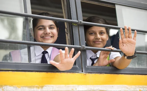 Boldog iskolás gyermekek integetett kézzel ablakból iskolabusz — Stock Fotó