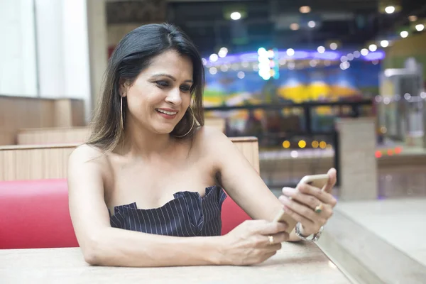 Mujer india joven usando teléfono móvil en la cafetería — Foto de Stock
