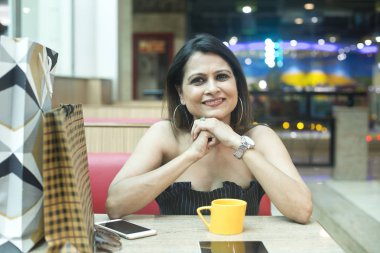 Kafede kahve içen ve cep telefonu kullanan kadın
