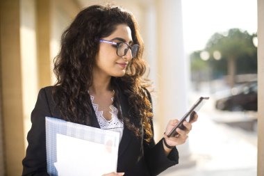 Kafede cep telefonu kullanan hintli genç kadın