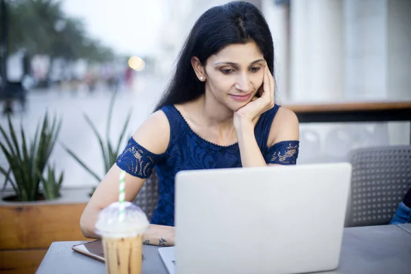 Kahve ve laptoplu güzel bir kadın açık kafede.