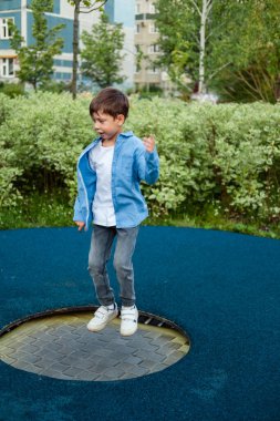 Çocuk parkında. Çocuk trambolinde zıplıyor. Karantina sırasında yürü