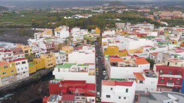 Tenerife, Punta Brava, İspanya - 18 Mayıs, 2018:Aerial görünümü renkli evlerin Atlantik kıyısında küçük bir kasaba. 4 k yukarıdan atış robot