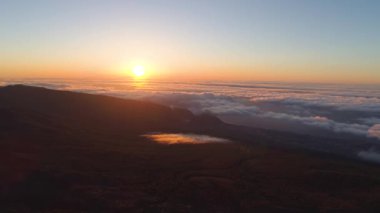 Havadan görünümü Teide Milli Parkı, dağlar ve aşağıda sertleştirilmiş lav bulutlara günbatımı üzerinde uçuş. Tenerife, Kanarya Adaları