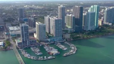 Miami, Florida, Abd - Ocak 2019: Güneşli bir günde Biscayne Körfezi'ndeki Miami Edgewater bölgesi üzerinde bulutlu hava aracı görünümü uçuşu. İskelede yatlar ve tekneler var. Lüks konut binaları