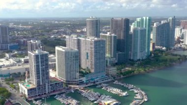 Miami, Florida, Abd - Ocak 2019: Güneşli bir günde Biscayne Körfezi'ndeki Miami Edgewater bölgesi üzerinde bulutlu hava aracı görünümü uçuşu. İskelede yatlar ve tekneler var. Lüks konut binaları