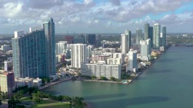 Miami, Florida, Abd - Ocak 2019: Güneşli bir günde Biscayne Körfezi'ndeki Miami Edgewater bölgesi üzerinde bulutlu hava aracı görünümü uçuşu. İskelede yatlar ve tekneler var. Lüks konut binaları
