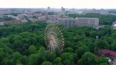 Minsk, Beyaz Rusya - Mayıs, 2019: Eğlence parkı nın havadan drone görünümü Dönme dolap cazibe rekreasyon yeşil ağaçlar ve arka planda özel evler