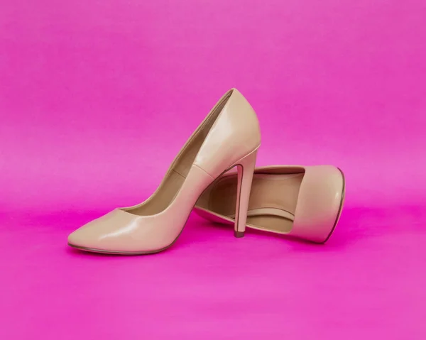 Beige high heel shoes isolated on the pink background