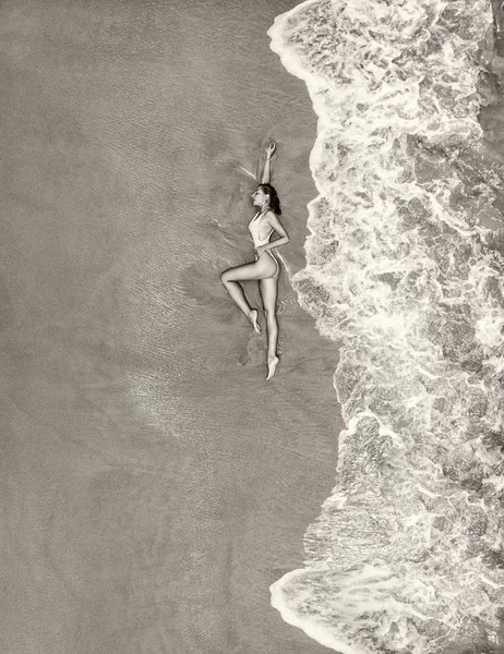 Belle jeune femme sur la plage, la couvre d'une vague — Photo