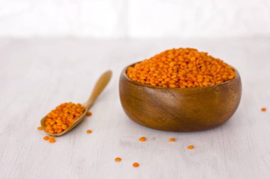 Ahşap kase ve beyaz masa kaşık çiğ kırmızı mercimek