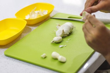 Eller taze sarımsak mutfakta yeşil kartı üzerindeki kesme