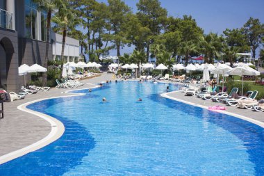Kemer, Antalya, Türkiye - 19 Temmuz, 2018: Barut otel Mavi yaz göğün altında yüzme insanlarla büyük havuzu