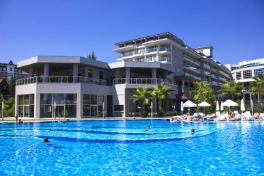 Kemer, Antalya, Türkiye - 19 Temmuz, 2018: Barut otel Mavi yaz göğün altında yüzme insanlarla büyük havuzu