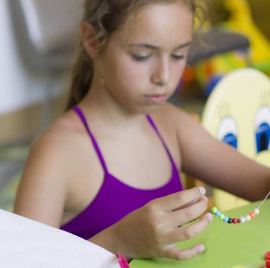 İpte boncuk çekimi iğne işi, genç güzel kız