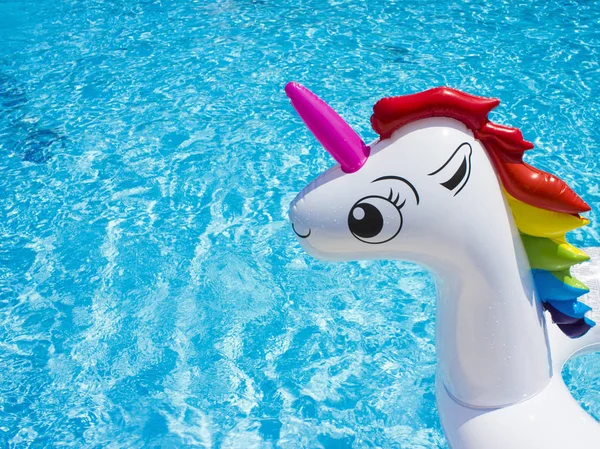 Inflatable toy white unicorn at the pool