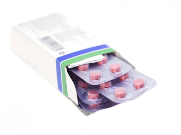 Pílulas cor de rosa em um pacote isolado em um fundo branco — Fotografia de Stock