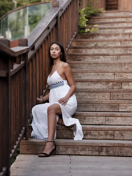 Hermosa Chica Morena Vestido Blanco Sienta Escaleras Madera Parque —  Fotos de Stock