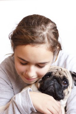 Mutlu oldukça gülümseyen genç kız şirin pug köpek sevgi ile sarılma