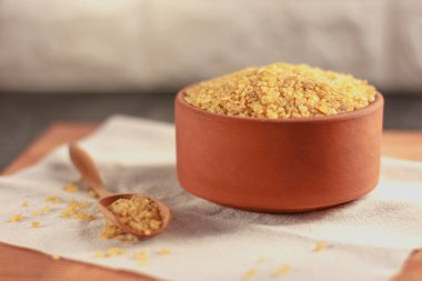 Ahşap tahta üzerinde bir kil kase çiğ bulgur