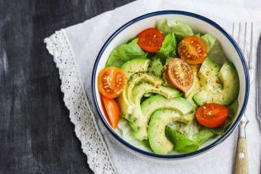 Vejetaryen salata avokado, roka, domates ve kuru otlar ile.