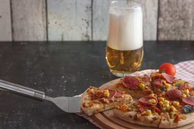 Mısır, sosis, domates ahşap tahta ve köpük bardakta light bira pizza