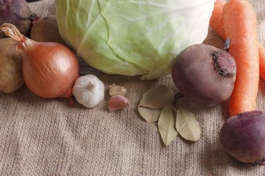 Pancar çorbası borsch için çiğ sebze. Beyaz lahana, pancar, havuç, patates, domates, sarımsak ahşap tahta üzerinde