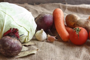 Pancar çorbası borsch için çiğ sebze. Beyaz lahana, pancar, havuç, patates, domates, sarımsak ahşap tahta üzerinde