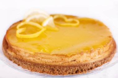 Limonlu cheesecake beyaz zemin üzerine limon lezzet yakın çekim ile dekore edilmiştir.