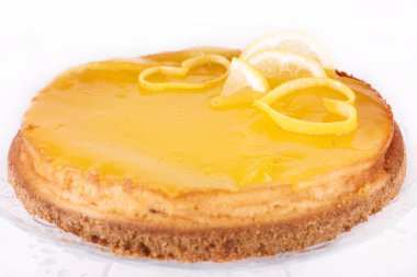 Limonlu cheesecake beyaz zemin üzerine limon lezzet yakın çekim ile dekore edilmiştir.