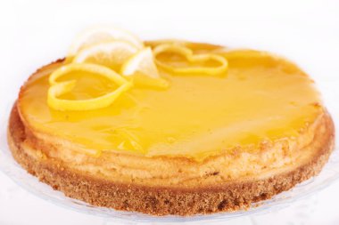 Limonlu cheesecake beyaz zemin üzerine limon lezzet yakın çekim ile dekore edilmiştir.