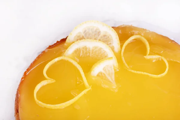 Lemon cheesecake on a white background decorated with lemon zest close-up