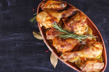 Çanak çömlek fırında pişmiş kırmızı biber soslu tavuk. Tavuk budu ve kanatlar