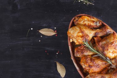 Çanak çömlek fırında pişmiş kırmızı biber soslu tavuk. Tavuk budu ve kanatlar