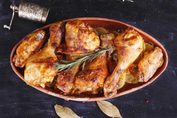 Çanak çömlek fırında pişmiş kırmızı biber soslu tavuk. Tavuk budu ve kanatlar