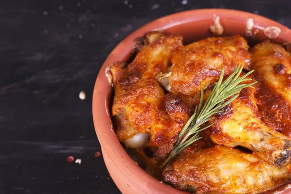 Pollo en salsa de pimentón cocido en el horno en cerámica. Patas y alas de pollo —  Fotos de Stock