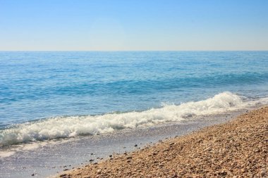 Antalya 'da Akdeniz manzarası, Türkiye. Mavi deniz, dalgalar ve çakıl kumlu plaj
