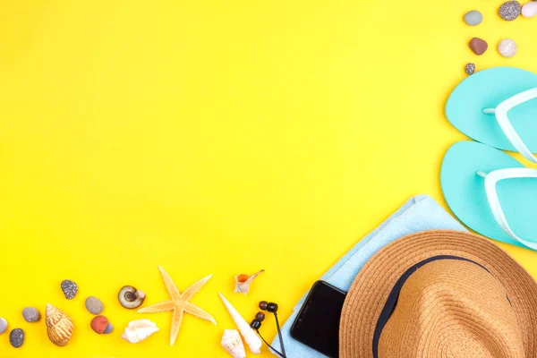 Occhiali da sole, crema solare, cuffie, smartphone, asciugamano, pantofole. Flatlay vacanza al mare su uno sfondo giallo . — Foto Stock