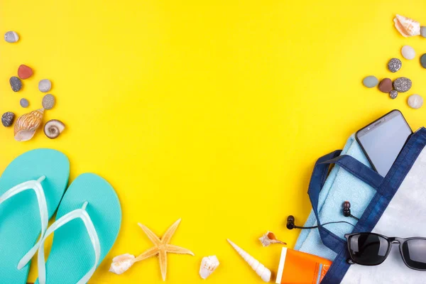 Sonnenbrille, Sonnenschutz, Kopfhörer, Smartphone, Handtuch, Hausschuhe. flacher Strandurlaub auf gelbem Hintergrund. — Stockfoto