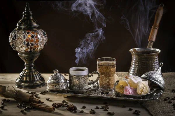 Café turco en cezve y deleite turco tradicional. Vapor sobre una taza. Lámpara antigua — Foto de Stock