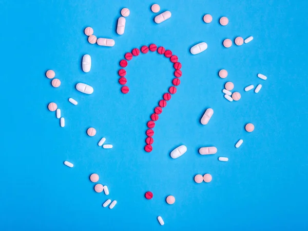 Question mark made from red medicine pills on blue background — Stock Photo, Image